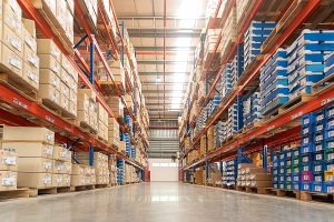 Rows of shelves with goods boxes in huge distribution 